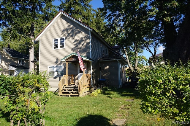 rear view of property featuring a lawn