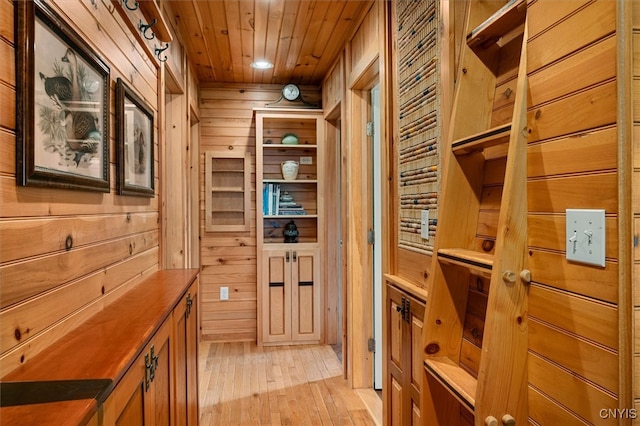 interior space featuring light hardwood / wood-style flooring, wood walls, and wood ceiling