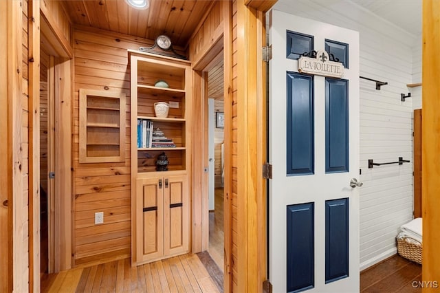 hallway featuring wooden walls, wood-type flooring, and wooden ceiling