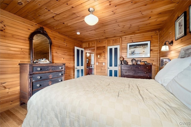 bedroom with light wood-type flooring, wood walls, and wooden ceiling