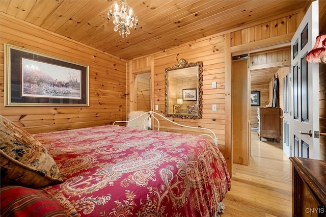 bedroom featuring wood walls, light hardwood / wood-style floors, and wooden ceiling