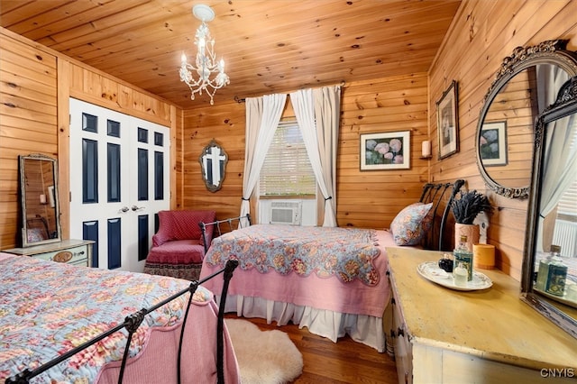 bedroom featuring cooling unit, hardwood / wood-style floors, a notable chandelier, wood walls, and wooden ceiling