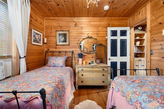 bedroom with light hardwood / wood-style flooring, wooden walls, and wooden ceiling