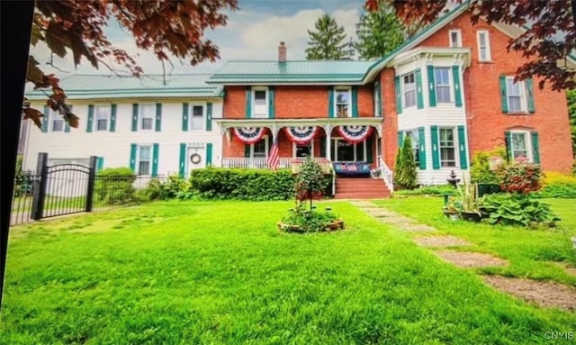 rear view of house with a chimney, fence, and a lawn