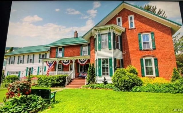 view of front of property featuring covered porch and a front yard