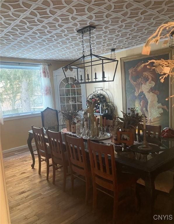 dining room featuring light wood finished floors and an ornate ceiling