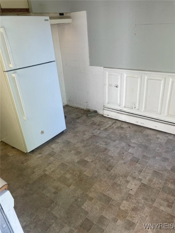 kitchen featuring white cabinets, a baseboard heating unit, and white refrigerator