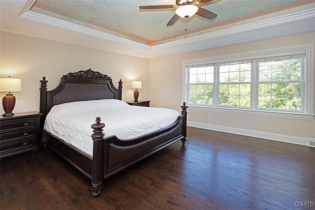 bedroom featuring ceiling fan, crown molding, dark hardwood / wood-style flooring, and a raised ceiling