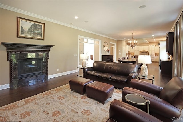 living room with a chandelier, crown molding, dark hardwood / wood-style floors, and a tile fireplace