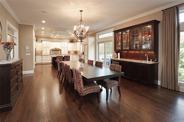 dining space featuring dark wood-type flooring, ornamental molding, and a notable chandelier