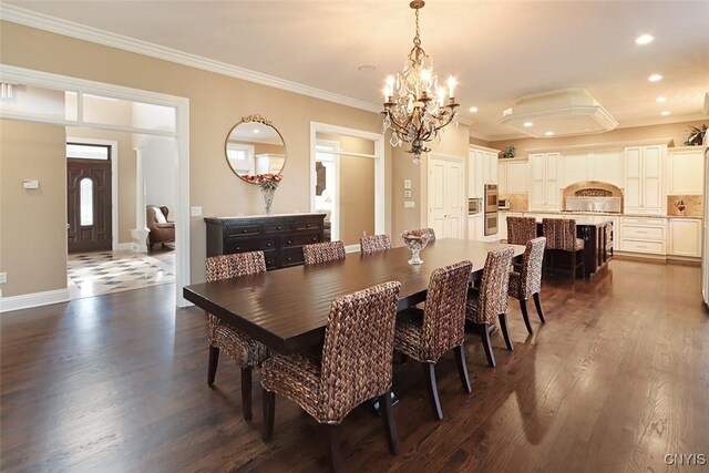 dining space featuring dark hardwood / wood-style flooring, crown molding, and a chandelier