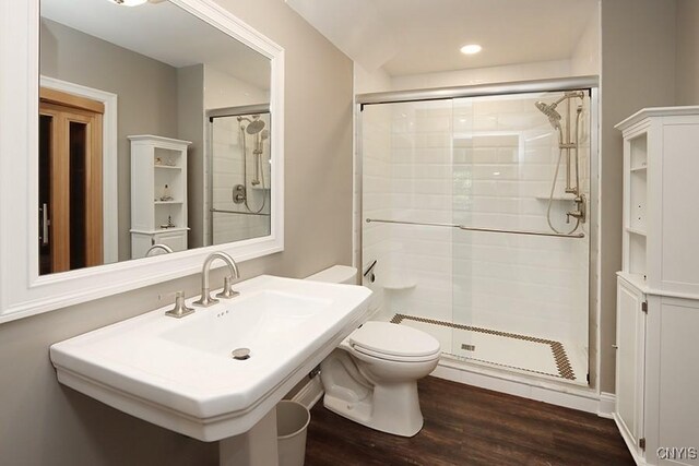 bathroom with a shower with shower door, sink, toilet, and hardwood / wood-style floors