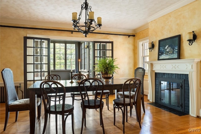 dining space featuring ornamental molding, a chandelier, and wood-type flooring