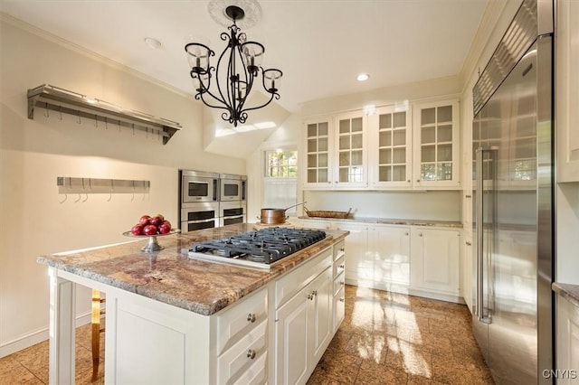 kitchen with a chandelier, glass insert cabinets, built in appliances, light stone countertops, and recessed lighting