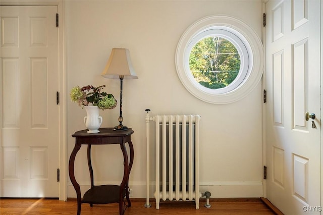 entryway with radiator, baseboards, and light wood finished floors
