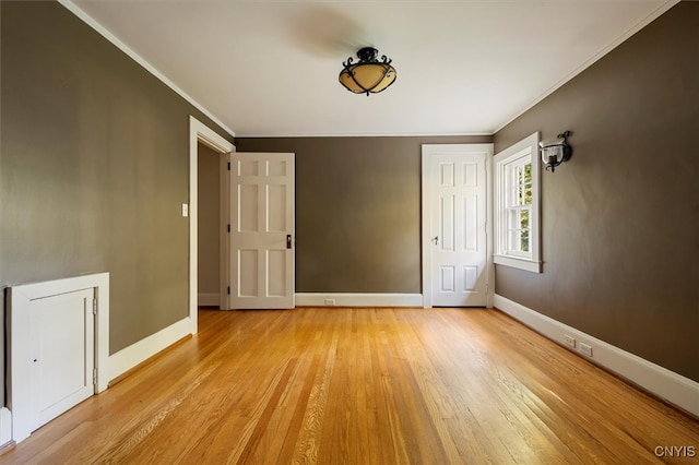 unfurnished bedroom with crown molding and light wood-type flooring