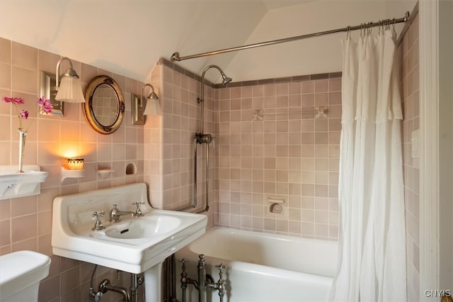 bathroom with tile walls, shower / bath combo with shower curtain, toilet, and tasteful backsplash