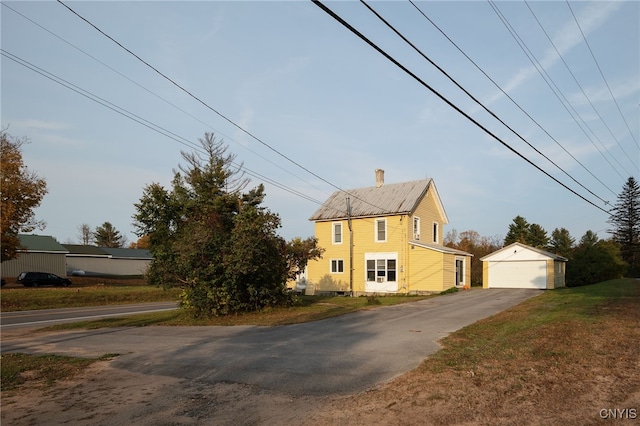 view of property exterior with a garage and an outbuilding