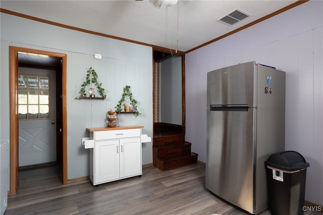 kitchen featuring stainless steel fridge, dark wood-type flooring, butcher block counters, ornamental molding, and white cabinets