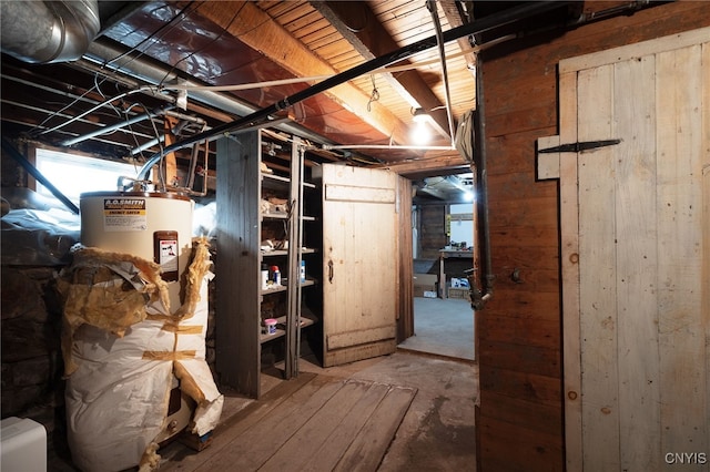 basement with electric water heater and wooden walls