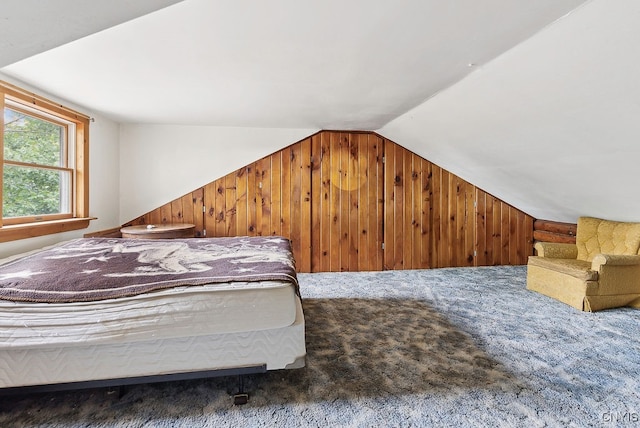 carpeted bedroom with wooden walls and lofted ceiling