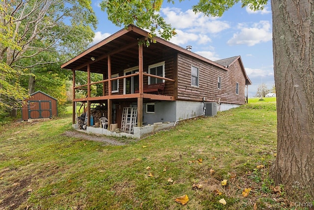 back of house featuring central AC unit, a storage shed, and a yard