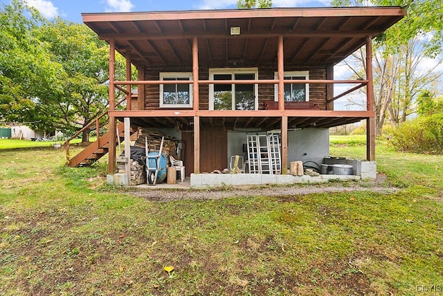 back of property with a lawn, a patio area, and a wooden deck