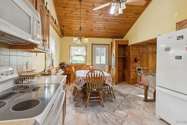 dining room featuring ceiling fan with notable chandelier, high vaulted ceiling, wooden walls, and wood ceiling