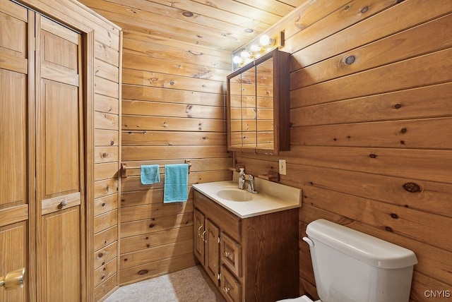 bathroom featuring wood walls, vanity, wooden ceiling, and toilet