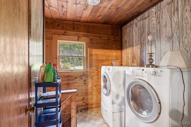 washroom featuring washer and clothes dryer, wooden ceiling, and wooden walls