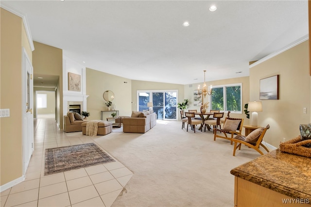 tiled living room with a fireplace, crown molding, vaulted ceiling, and an inviting chandelier