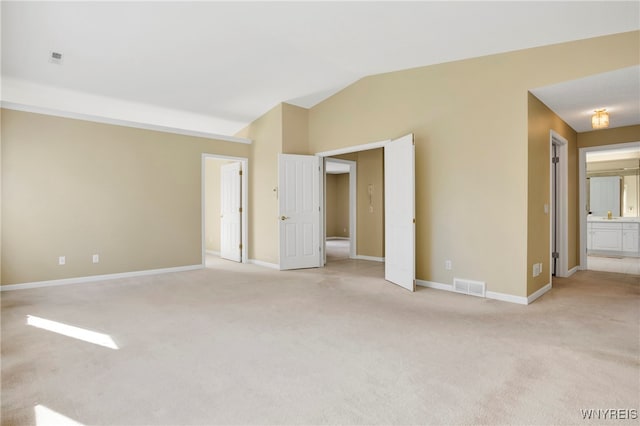 interior space with light colored carpet and lofted ceiling