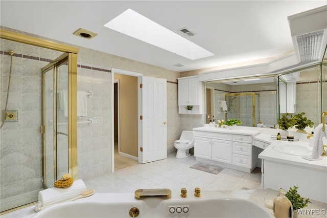 full bathroom with vanity, plus walk in shower, tile patterned floors, a skylight, and toilet