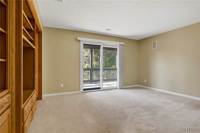 carpeted empty room with a textured ceiling