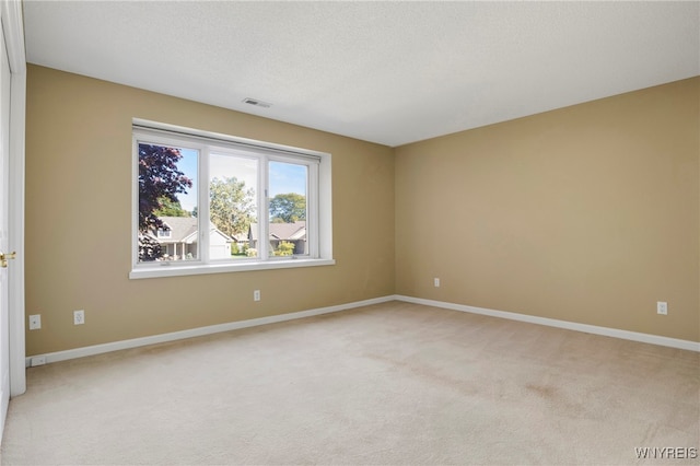 carpeted spare room with a textured ceiling