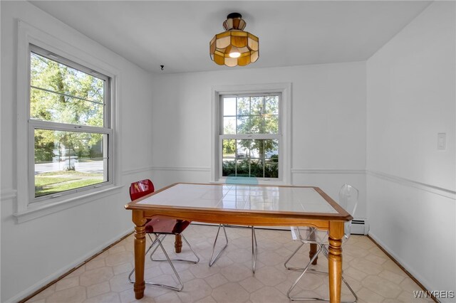 dining area with plenty of natural light and a baseboard heating unit