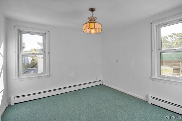 carpeted spare room featuring a baseboard radiator and plenty of natural light