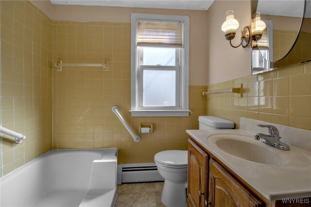 bathroom with a tub, vanity, tile walls, a baseboard heating unit, and toilet