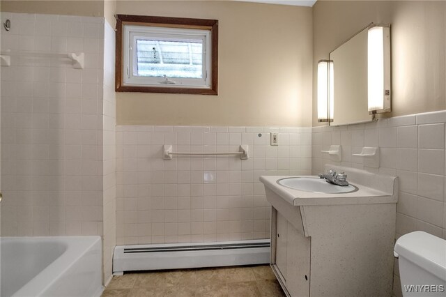 bathroom featuring vanity, a bathing tub, a baseboard heating unit, tile walls, and toilet