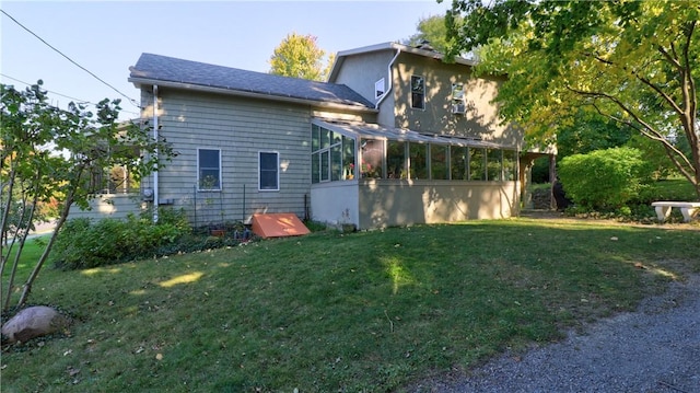 view of property exterior featuring a sunroom and a yard