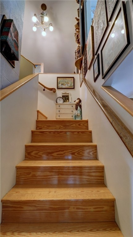 stairway featuring an inviting chandelier