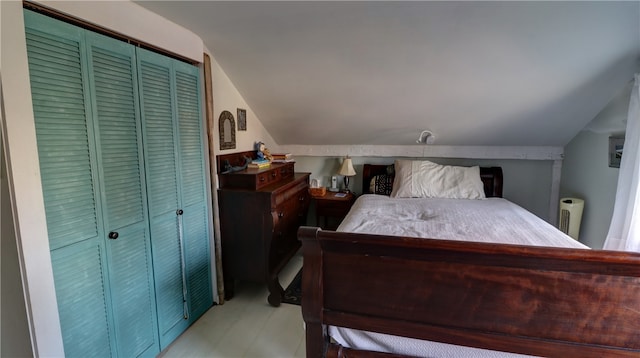 bedroom with radiator heating unit, vaulted ceiling, and a closet