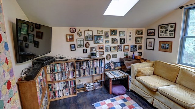 sitting room featuring hardwood / wood-style floors and lofted ceiling with skylight