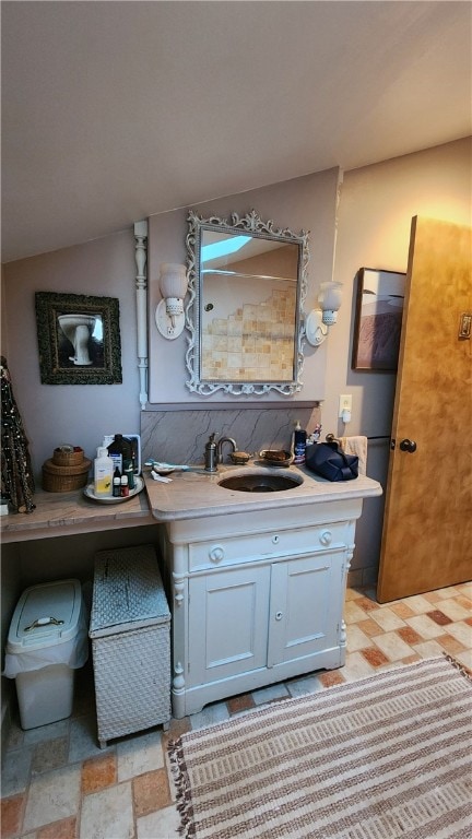 bathroom featuring vanity and lofted ceiling