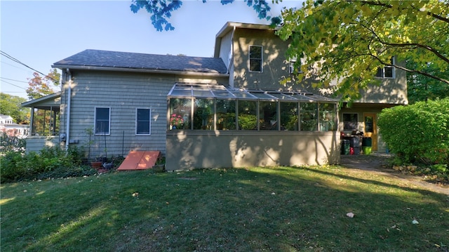 back of house with a lawn and a sunroom