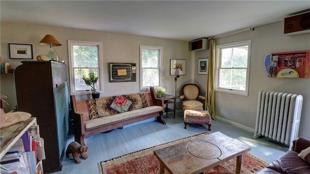 interior space with radiator, a wall mounted AC, and a healthy amount of sunlight