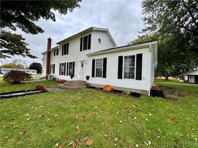 view of front of house with a front yard and central AC unit