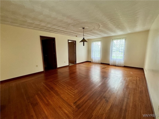 unfurnished room with a textured ceiling and wood-type flooring