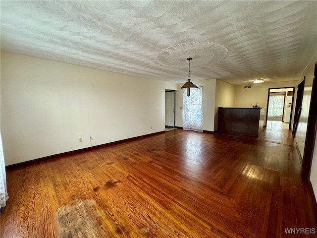 empty room with a textured ceiling and hardwood / wood-style floors