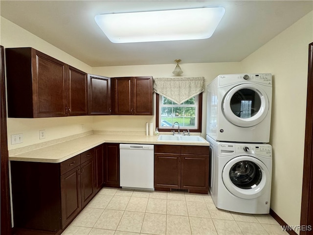 laundry room featuring stacked washer and clothes dryer, sink, and light tile patterned floors